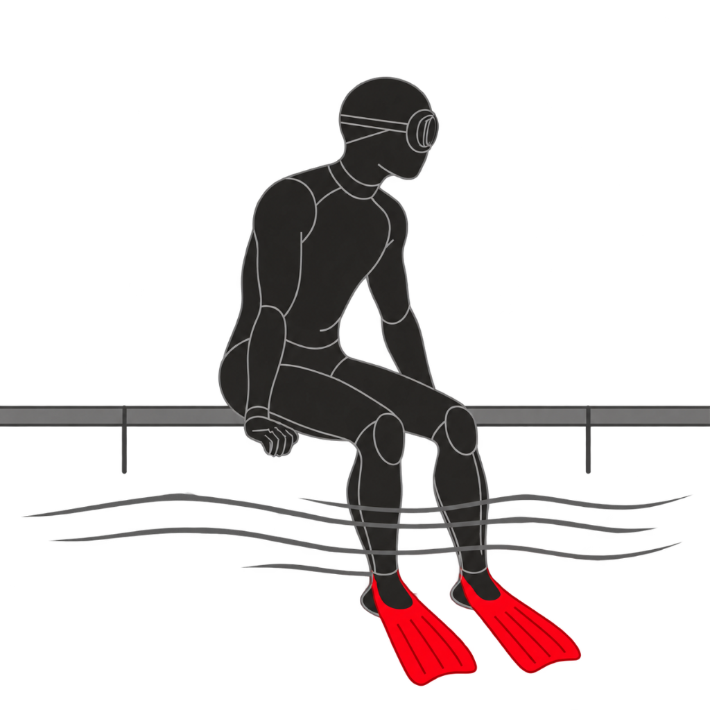Freediver sitting at the pool edge in red Lobster Fins